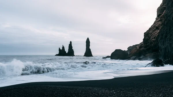曇り空の黒砂の浜と並ぶ岩柱の壁紙 - 海・湖・水辺