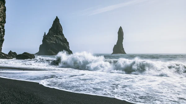 黒い砂浜に打ち寄せる波と岩の尖塔の壁紙 - 海・湖・水辺 / 自然・風景